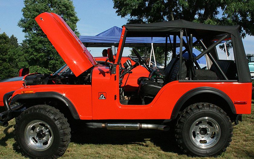 Red Jeep off-road vehicle with lifted suspension and open hood